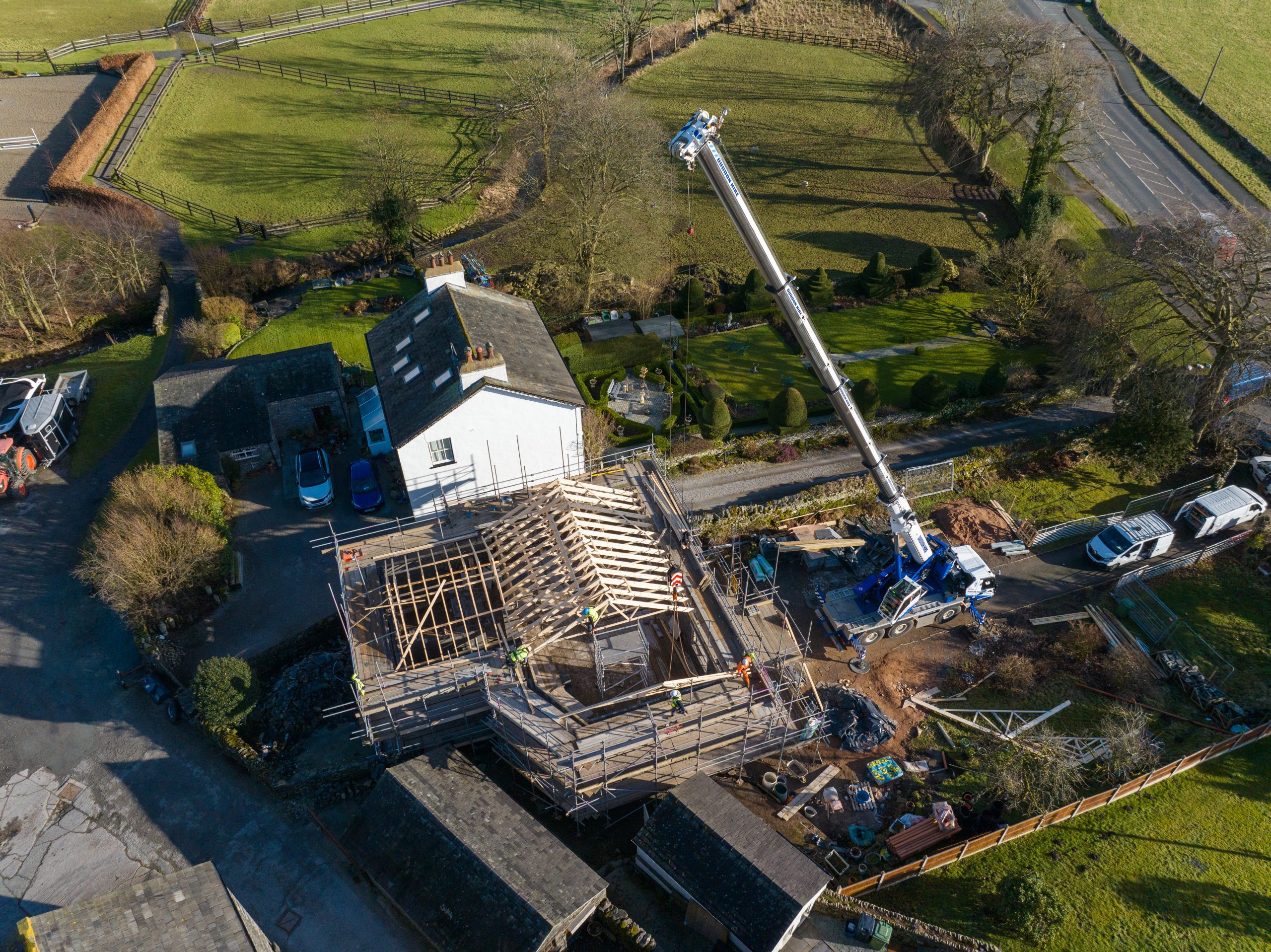 Crane Lowering roofing joists onto bespoke development